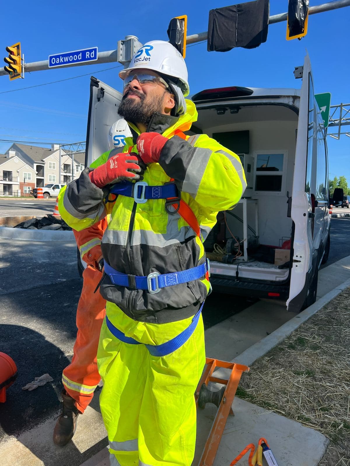 SRVacJet crew member in a safety harness on a live job site